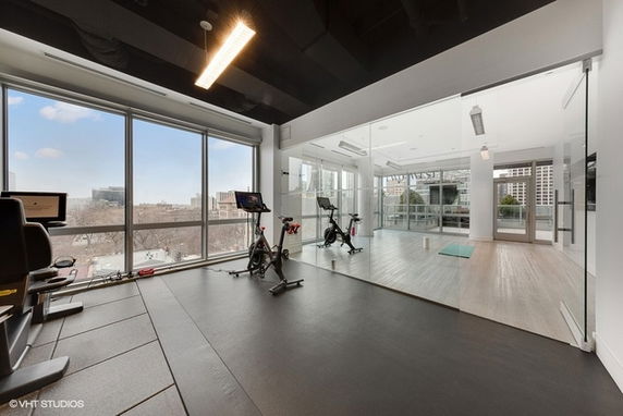 Interior view of a fitness area with exercise bikes and a large window.