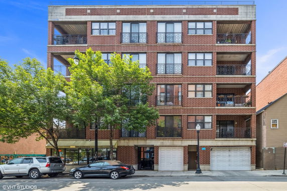 Front view of a multi-story brick building with balconies.