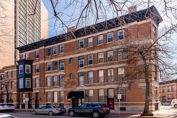 Front view of a multi-story brick building with multiple windows.