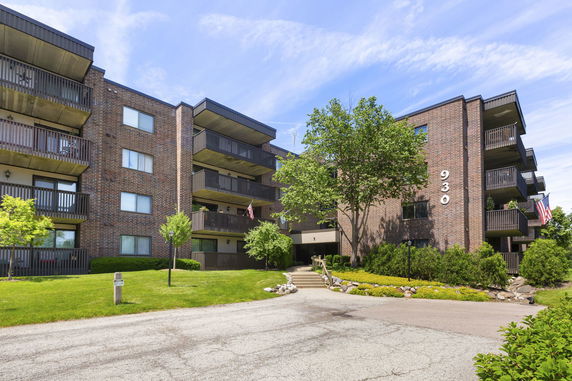 Front view of a multi-story brick apartment building with balconies.