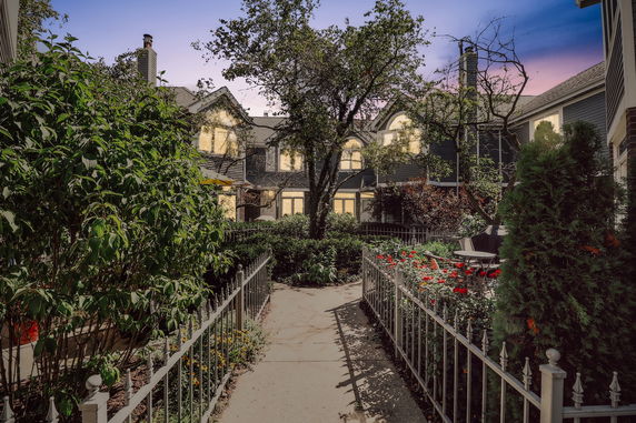 Front view of a multi-story building with a garden and pathway.