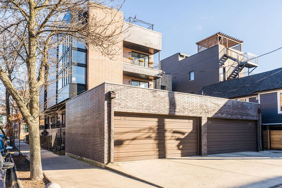 Front view of a multi-story building with brick exterior and attached garage.