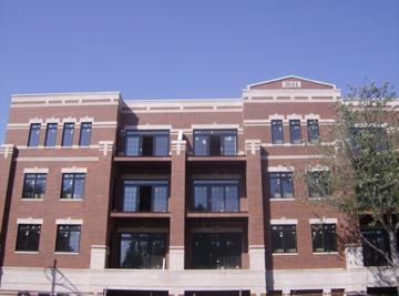 Front view of a multi-story brick building with multiple windows and balconies.