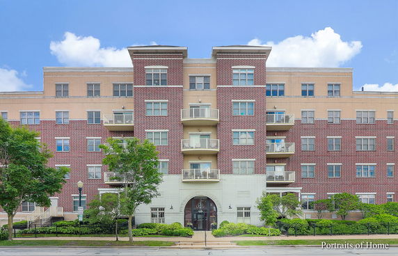 Front view of a multi-story apartment building with a brick facade and balconies.