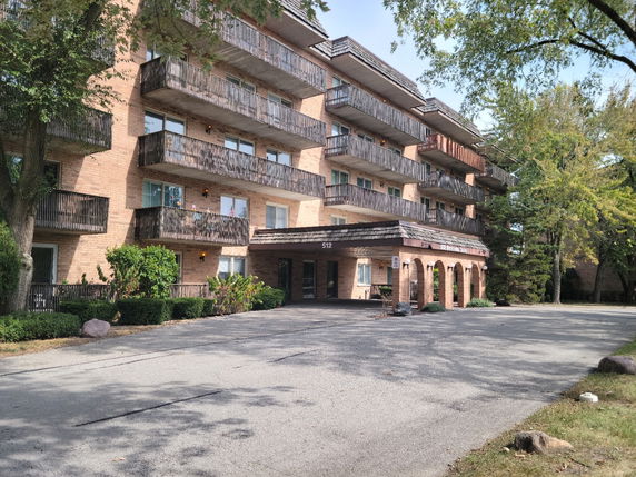 Front view of a multi-story apartment building with balconies.