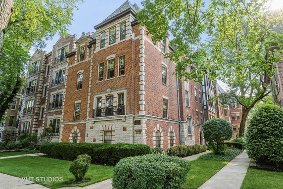 Front view of a multi-story brick building with arched windows and ornate details.
