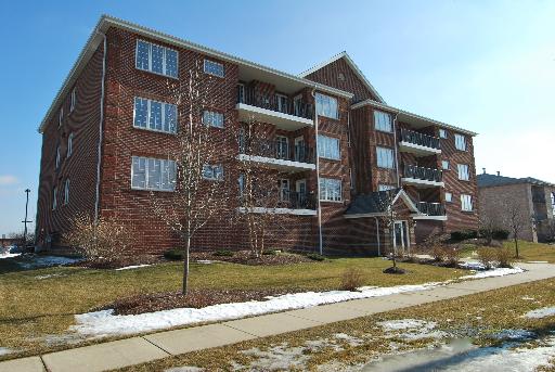 Front view of a multi-story apartment building with balconies.