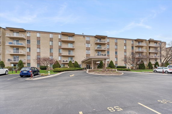 Front view of a multi-story apartment building with balconies.