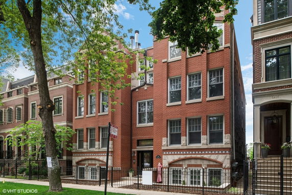Front view of a multi-story brick building with multiple windows and an entrance.