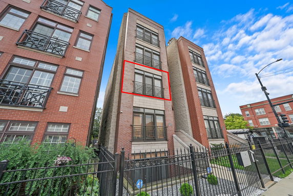 Front view of a multi-story red brick apartment building.