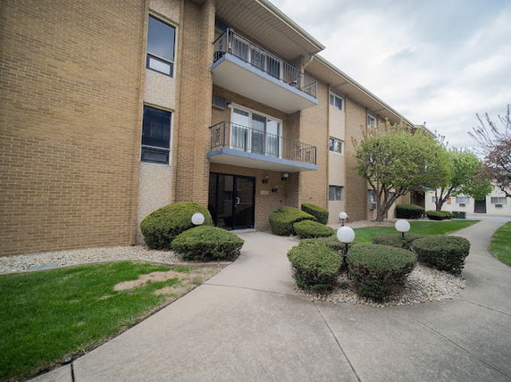 Front view of a multi-story brick building with balconies.