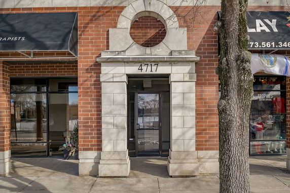 Front view of a commercial building entrance with brick and stone facade.