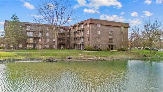 Front view of a multi-story brick apartment building by the water.