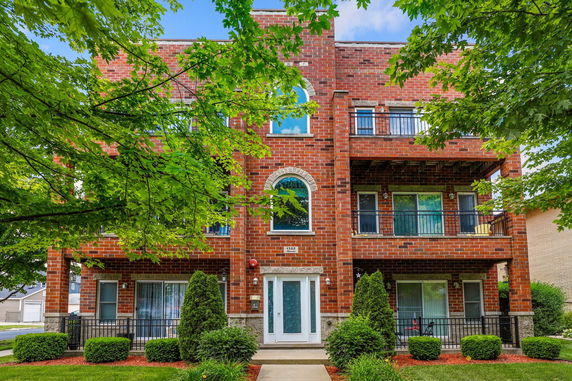 Front view of a brick multi-story building with balconies.