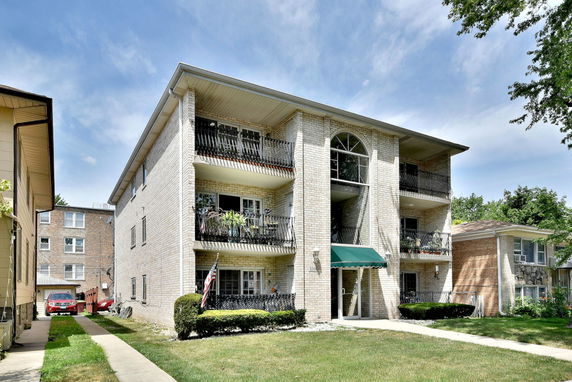 Front view of a three-story apartment building with balconies.