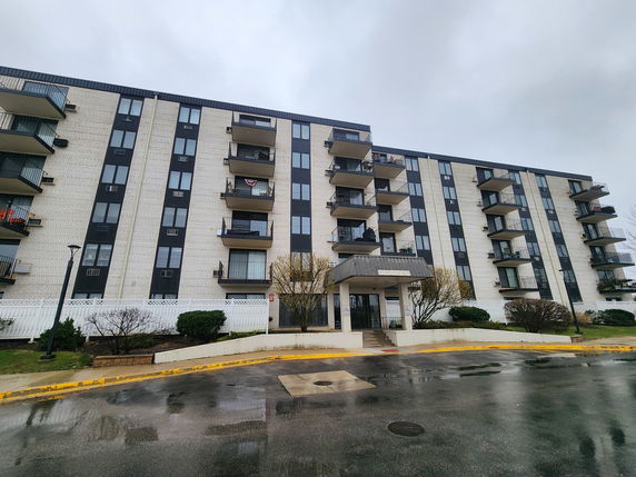 Front view of a multi-story residential building with balconies.