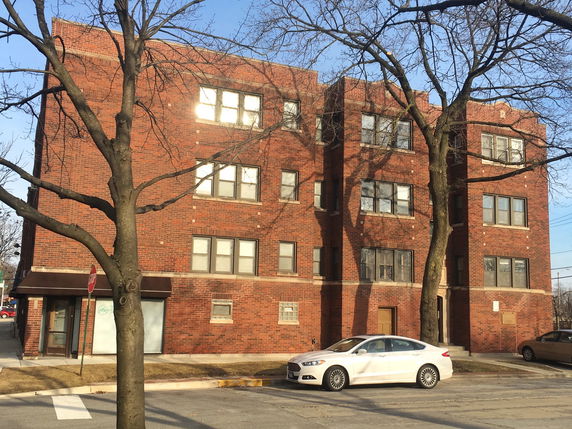 Front view of a multi-story brick apartment building.