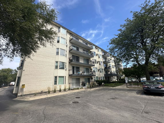 Front view of a multi-story apartment building with balconies.