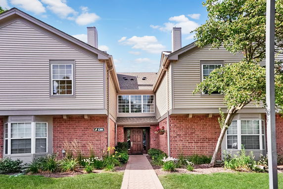 Front view of a two-story house with brick and siding exterior.