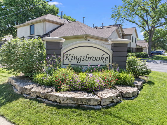 Front view of a multi-story residential building with a sign stating 'Kingsbrooke.'