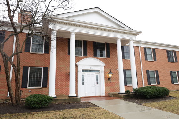 Front view of a two-story brick building with white columns.