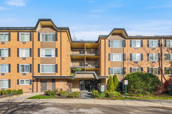 Front view of a multi-story building with multiple windows and balconies.