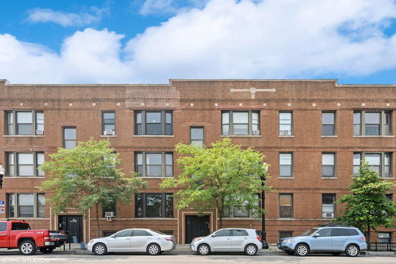 Front view of a three-story brick apartment building.
