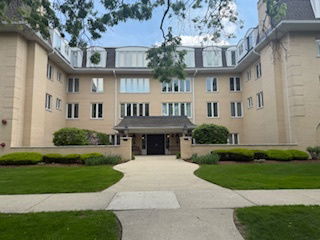 Front view of a multi-story building with multiple windows and an entrance pathway.