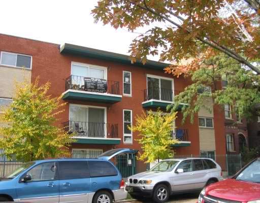 Front view of a three-story apartment building with balconies.