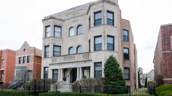 Front view of a three-story brick building with decorative stone elements.