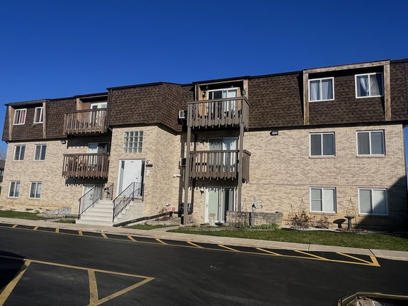 Front view of a multi-story residential building with balconies.