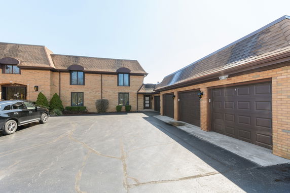 Front view of a building with a connected garage and multiple windows.