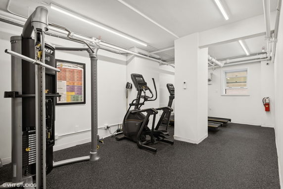 Indoor gym area with exercise equipment, including a treadmill and elliptical machines.