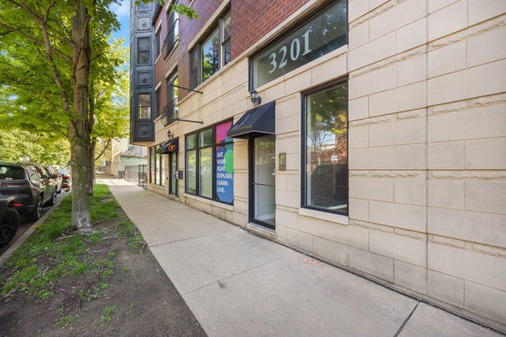 Front view of a mixed-use building with brick and stone facade.