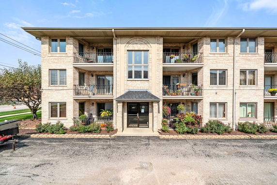 Front view of a multi-story apartment building with balconies.