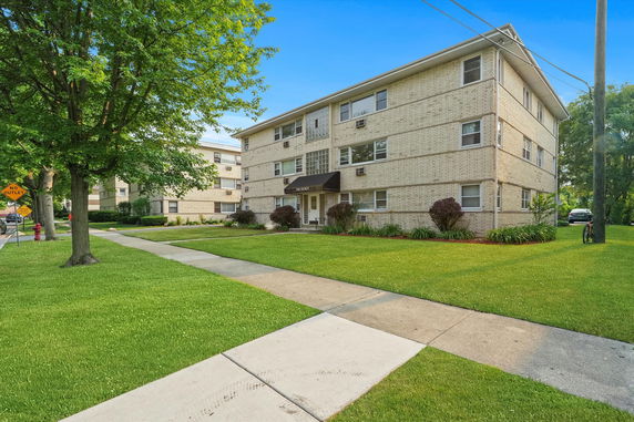 Front view of a three-story apartment building with a brick exterior.