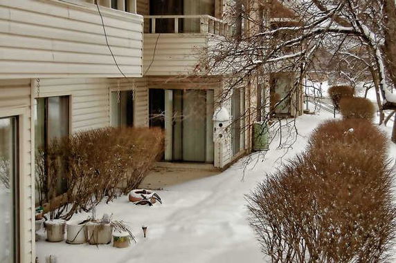 Exterior view of a residential building with balconies and sliding doors during winter.