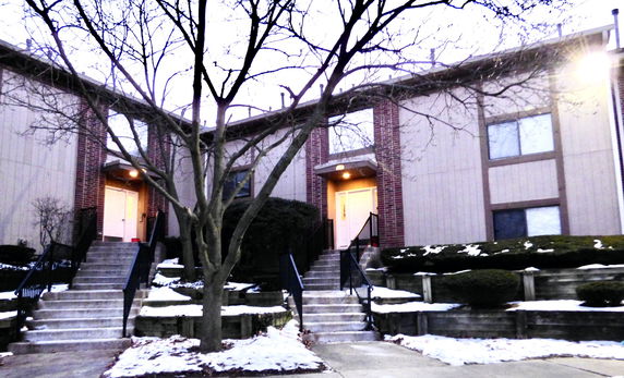 Front view of a residential building with stairs leading to entrances.