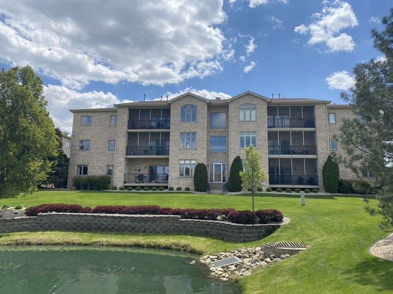 Front view of a multi-story building with balconies and brick exterior.