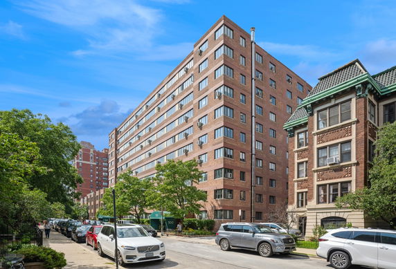 Front view of a multi-story building with numerous windows and a brick facade.