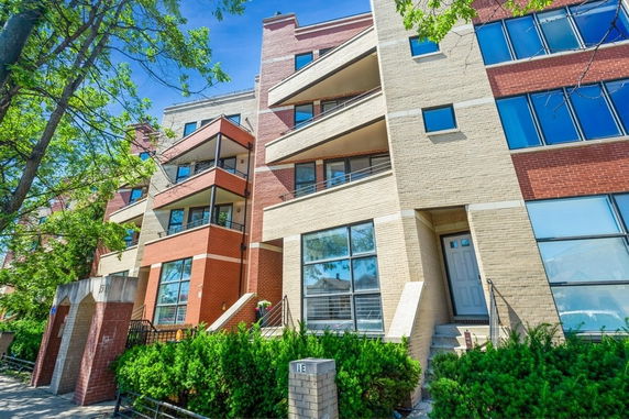 Front view of a multi-story residential building with brick and beige exterior.