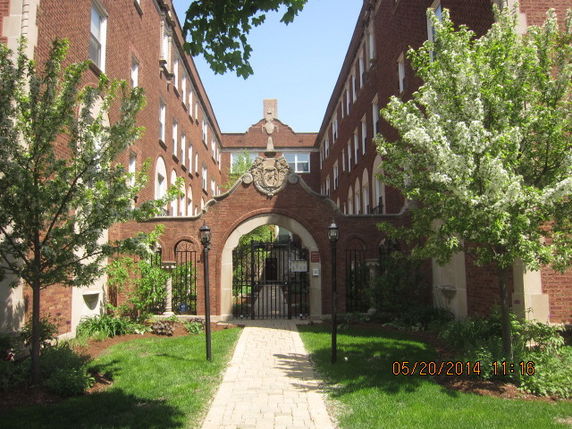 Front view of a multi-story brick building with an arched entrance.