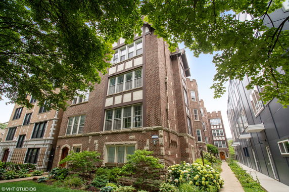 Front view of a multi-story brick building with large windows.