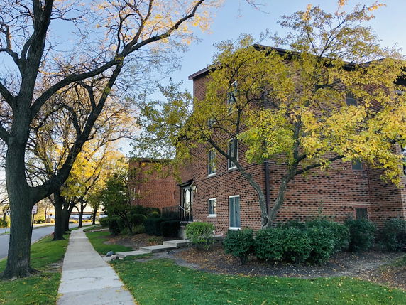 Side view of a brick residential building with trees nearby