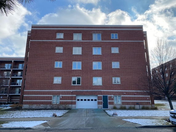 Front view of a multi-story brick building with a garage entrance.
