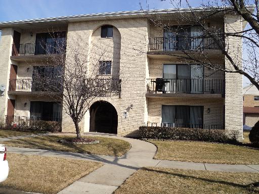 Front view of a three-story apartment building with balconies.