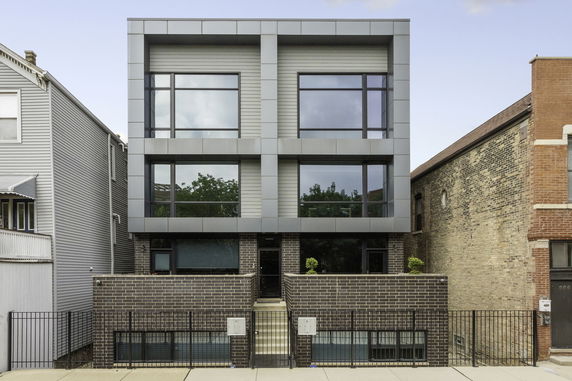 Front view of a modern two-story building with large windows and a brick exterior.