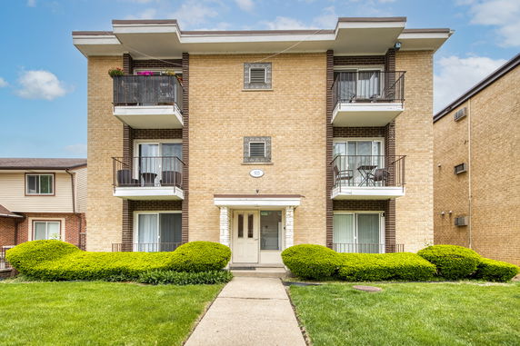Front view of a multi-story apartment building with balconies.