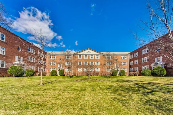 Front view of a brick apartment building with a symmetrical design.