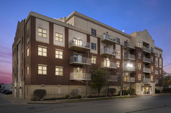 Front view of a multi-story apartment building with balconies.